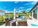 Outdoor patio with wicker furniture, blue cushions, and a view of the lush green lawn at 279 Park Forest Blvd, Englewood, FL 34223