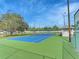 Enjoy a match on this well-maintained tennis court with vibrant blue and green surfaces on a sunny day at 279 Park Forest Blvd, Englewood, FL 34223