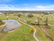 Scenic aerial view of the lush green golf course with ponds and mature trees and winding golf cart paths at 29353 Princeville Dr, San Antonio, FL 33576