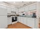 Well-lit kitchen featuring white appliances and cabinets with a view to the adjacent room at 29353 Princeville Dr, San Antonio, FL 33576