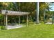 Lush backyard featuring a pergola over a stone firepit and a dock near the waterfront at 310 79Th Nw St, Bradenton, FL 34209