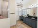 Bathroom showcases a vanity area, large mirror, stone floors, and tiled walk-in shower at 310 79Th Nw St, Bradenton, FL 34209