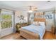 Bedroom features a rattan bed frame, hardwood floors, and natural light at 310 79Th Nw St, Bradenton, FL 34209