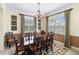 Formal dining room with hardwood table, decorative rug, and windows with plantation shutters at 310 79Th Nw St, Bradenton, FL 34209