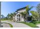 Charming two-story home with tan siding, white accents, palm trees, and a circular driveway at 310 79Th Nw St, Bradenton, FL 34209