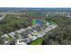 An aerial view shows the home nestled within a lush neighborhood with mature trees, a pond, and well-maintained lawns at 3116 Woodland Fern Dr, Parrish, FL 34219