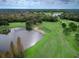 Expansive aerial showcases lush golf course with a pond, sand trap, and well-manicured green at 3116 Woodland Fern Dr, Parrish, FL 34219