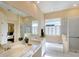 Bright bathroom featuring double sinks, soaking tub, and a separate glass-enclosed shower at 3116 Woodland Fern Dr, Parrish, FL 34219