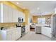 Bright kitchen featuring stainless steel appliances, ample counter space, and a view into the living room at 3116 Woodland Fern Dr, Parrish, FL 34219
