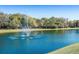 Scenic view of a peaceful pond with a central fountain, adding charm to the community landscape at 3116 Woodland Fern Dr, Parrish, FL 34219