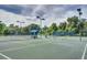 Well-maintained tennis court features professional lighting, shaded seating, and quality fencing at 3116 Woodland Fern Dr, Parrish, FL 34219