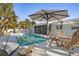 Outdoor pool area with patio furniture, palm trees, and a white umbrella, perfect for relaxing and entertaining at 329 Avenida Leona, Sarasota, FL 34242