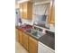 Galley kitchen offers a stainless steel sink, gray counters, and white appliances at 3351 Blue Bird Dr, Holiday, FL 34690