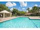 Sparkling community pool surrounded by lush greenery, lounge chairs, and a covered pavilion at 4008 Crockers Lake Blvd # 11, Sarasota, FL 34238