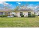 The back exterior of the house features a screened porch, windows, and a well-maintained lawn with some cactus at 4050 Oakhurst Dr # 3175, Sarasota, FL 34233