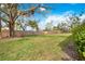 Large grassy backyard surrounded by a wooden fence and mature trees, providing ample space and privacy at 4050 Oakhurst Dr # 3175, Sarasota, FL 34233