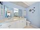 Well-lit bathroom with a large mirror, white cabinets, and blue accents at 4050 Oakhurst Dr # 3175, Sarasota, FL 34233