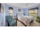 Serene bedroom features a comfy recliner and a coastal-themed patterned comforter at 4050 Oakhurst Dr # 3175, Sarasota, FL 34233