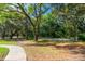 Community park featuring a paved trail, mature trees, and a grassy area for various recreational activities at 4050 Oakhurst Dr # 3175, Sarasota, FL 34233