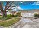 Inviting single-story home with a spacious driveway, attached garage, lush landscaping, and a welcoming entrance at 4050 Oakhurst Dr # 3175, Sarasota, FL 34233