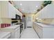 Bright kitchen features white cabinets, tile flooring, and modern appliances at 4050 Oakhurst Dr # 3175, Sarasota, FL 34233