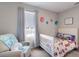 Cozy bedroom with soft lighting, white crib, armchair and neutral wall decor at 411 158Th E St, Bradenton, FL 34212