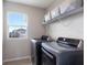 Bright laundry room features modern washer and dryer, a window, and overhead shelving at 411 158Th E St, Bradenton, FL 34212