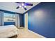 Blue-walled bedroom with tiled floor and bright ceiling fan at 4335 Maceachen Blvd, Sarasota, FL 34233