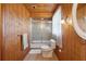Stylish bathroom featuring a glass shower door, wood paneling, and soft lighting at 441 Rubens E Dr, Nokomis, FL 34275