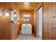Bright bathroom featuring wood paneling, white vanity, and decorative mirrors at 441 Rubens E Dr, Nokomis, FL 34275