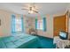 Relaxing bedroom featuring dual windows with bright blue sheers and a ceiling fan at 441 Rubens E Dr, Nokomis, FL 34275