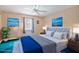 Comfortable bedroom with a queen bed, ceiling fan, and cool-toned wall decor at 441 Rubens E Dr, Nokomis, FL 34275