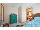 Bedroom with a green dresser, neutral walls, and a peek into a cozy living space at 441 Rubens E Dr, Nokomis, FL 34275