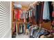 Walk-in closet featuring white tile floor, wood paneled walls, and plenty of hanging clothes at 441 Rubens E Dr, Nokomis, FL 34275