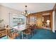 Dining room with wood table, chandelier, wood-paneled wall, and sliding glass doors at 441 Rubens E Dr, Nokomis, FL 34275