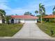 Charming single-story home with a long driveway and lush tropical landscaping at 441 Rubens E Dr, Nokomis, FL 34275