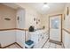 Hallway features white wainscoting, tile floors, wooden butcher block decorations and rear door at 441 Rubens E Dr, Nokomis, FL 34275