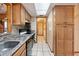 Galley kitchen with a skylight, stainless steel sink, light wood cabinets, and tile floor at 441 Rubens E Dr, Nokomis, FL 34275