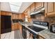Cozy kitchen featuring wood cabinets, black appliances, and bright, natural lighting through a skylight at 441 Rubens E Dr, Nokomis, FL 34275