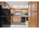 Kitchen featuring wood cabinets, a skylight, black appliances, and granite countertops at 441 Rubens E Dr, Nokomis, FL 34275
