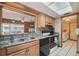 Galley kitchen with wood cabinets, black appliances, stainless steel sink, and tile flooring under a large skylight at 441 Rubens E Dr, Nokomis, FL 34275