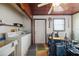 Laundry room featuring utility sink, laundry machine, wood paneled ceiling, and adjacent work space at 441 Rubens E Dr, Nokomis, FL 34275