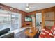 Living room featuring wood paneling, a ceiling fan, sliding glass doors, and views of the bedroom at 441 Rubens E Dr, Nokomis, FL 34275