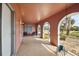 Covered and enclosed front porch with a pink roof and tan pebble stone flooring at 441 Rubens E Dr, Nokomis, FL 34275