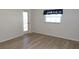 The bedroom features wood-look floors, a window, and a door with glass leading outside at 4412 Spicewood Dr # D, Bradenton, FL 34208