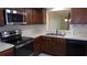Kitchen with stainless steel appliances, dark wood cabinets, and light countertops at 4412 Spicewood Dr # D, Bradenton, FL 34208