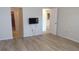 Bright living room featuring modern flooring, wall-mounted TV, and doorways to other areas of the house at 4412 Spicewood Dr # D, Bradenton, FL 34208