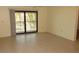 Spacious living area with neutral walls and tile floors and a sliding door providing access to the balcony at 4412 Spicewood Dr # D, Bradenton, FL 34208