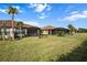 Large green backyard with chairs, palm trees, and screened lanai at 4721 Tortona Ct, Bradenton, FL 34211