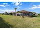 Expansive backyard featuring lush green grass, mature palm trees, and a screened-in patio with outdoor seating at 4721 Tortona Ct, Bradenton, FL 34211